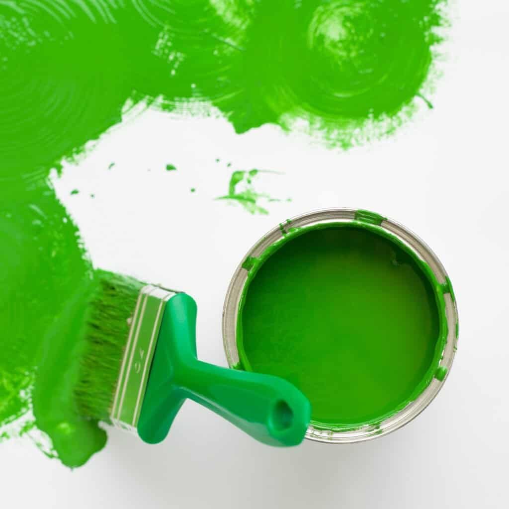 Bright green paint in an open can with a paintbrush, showcasing exterior and interior painting services offered by Central Coast Painter Corp. Perfect for residential and commercial painting projects.